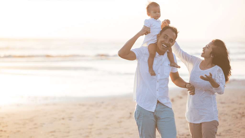 Happy family enjoying the beach - representing the benefits of consistent sleep training methods