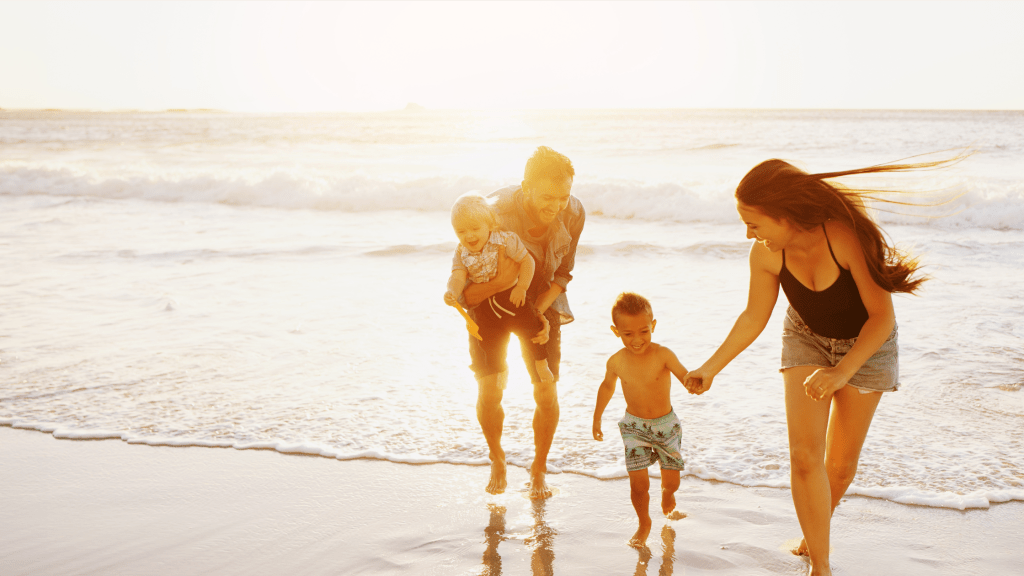 happy family on a beach representing the benefits of following travel sleep tips for children
